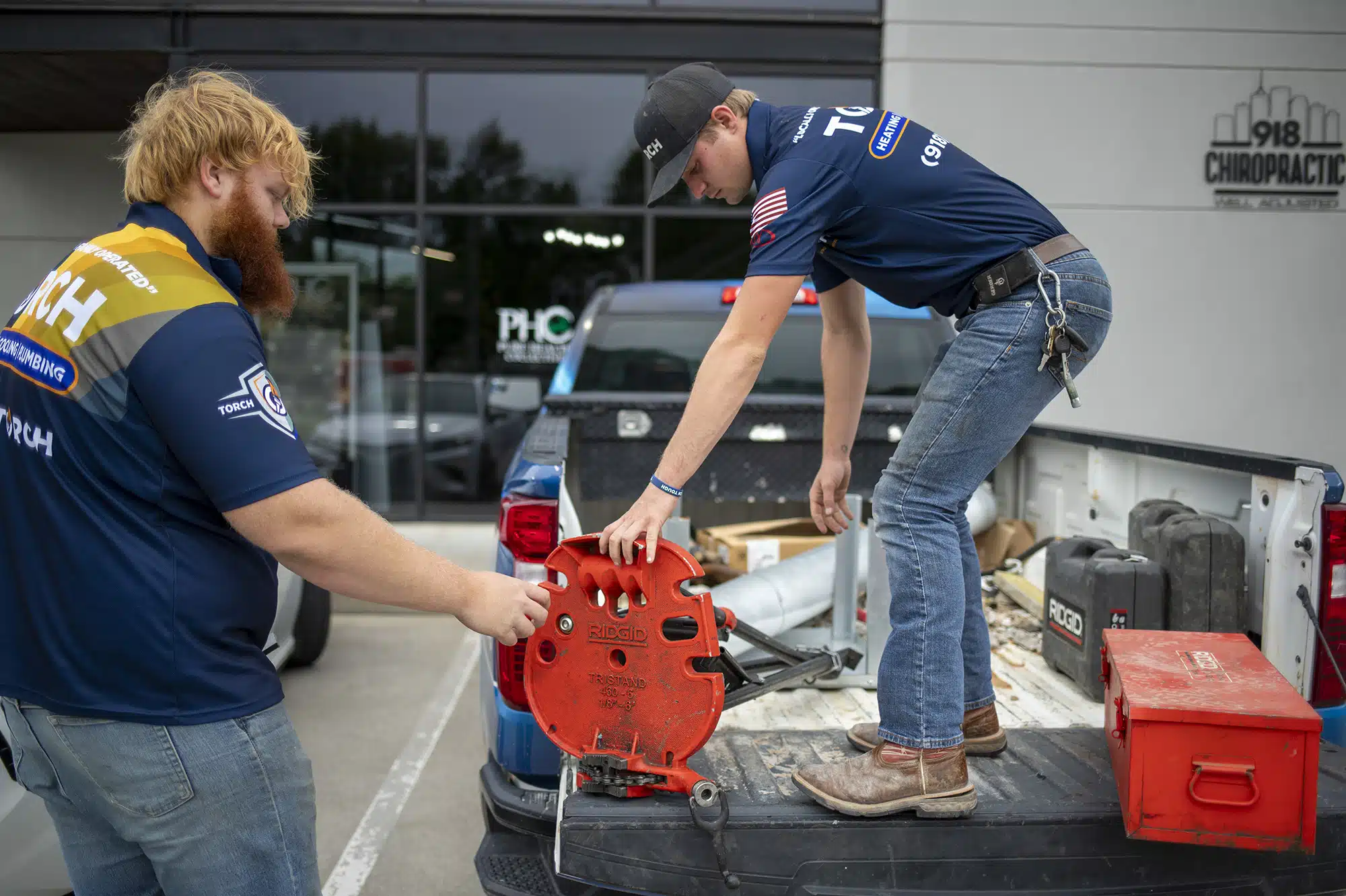 Two Torch Plumbing, Heating, & Cooling Heating, Cooling and Plumbing Technicians unloading tools from a truck in Owasso, OK