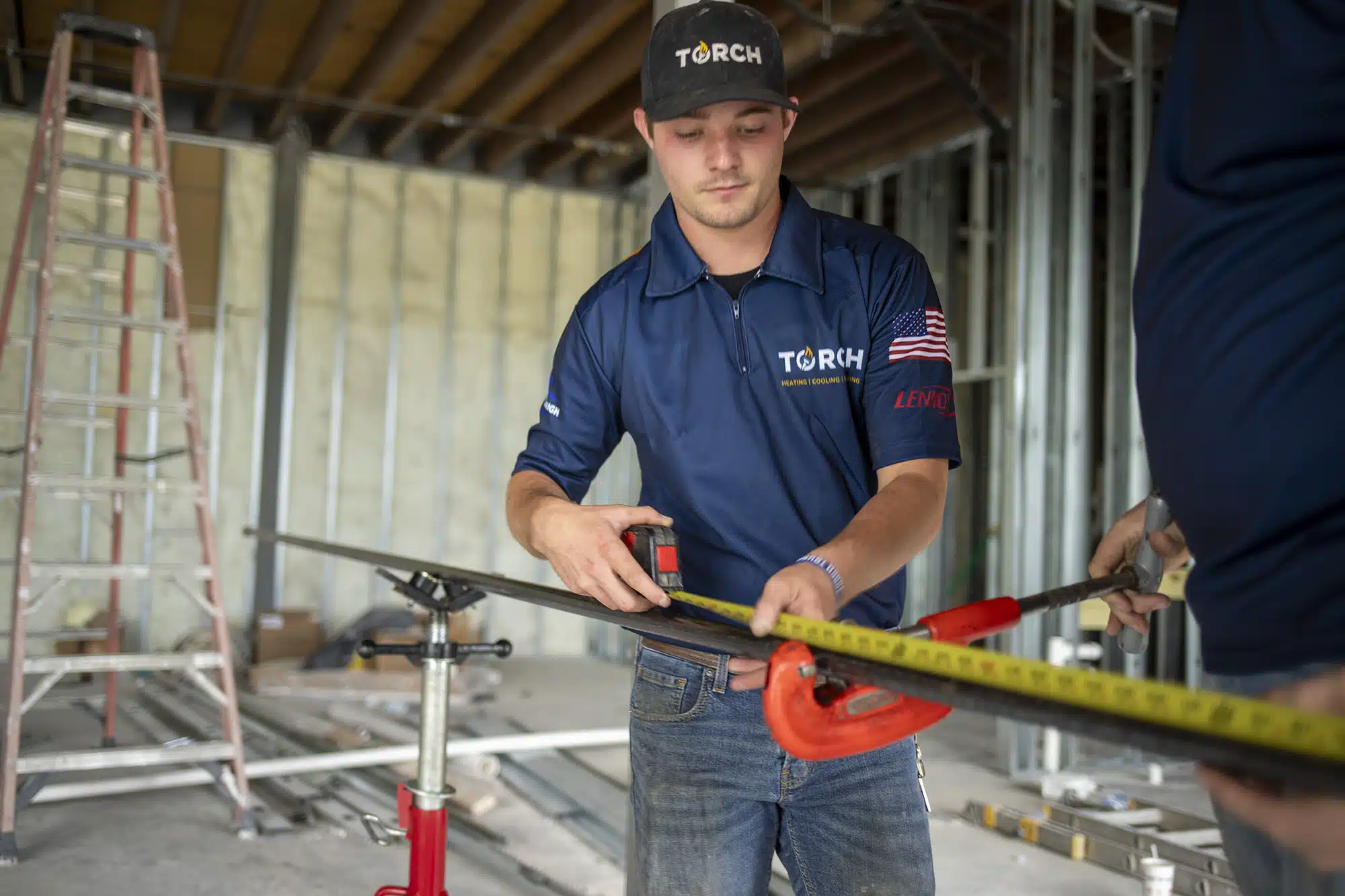 Plumber in Owasso, OK, measuring a pipe