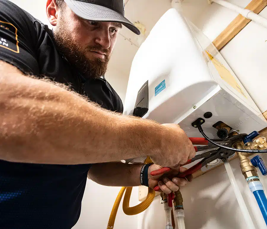 Torch technician repairing tankless water heater